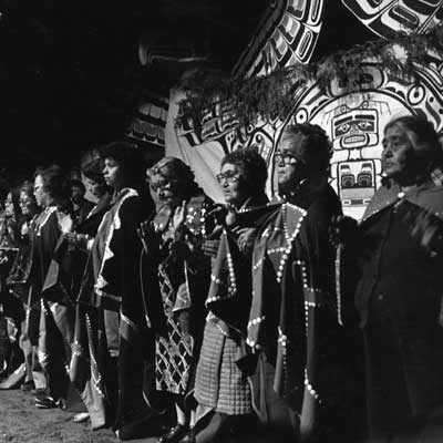 Black and White photograph of potlatch singing mourning songs at Owaxalagalis, Chief Roy Cranmer's Potlatch, 1980.