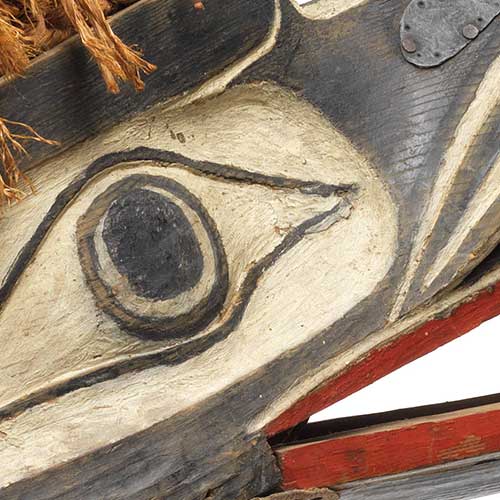 Photographie couleur un détail de l'œil du masque de Gwaxgwakalanuksiwe', le Corbeau de l'extrême-nord du monde