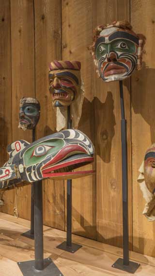 Installation photograph of the Potlatch Gallery showing a row of masks.