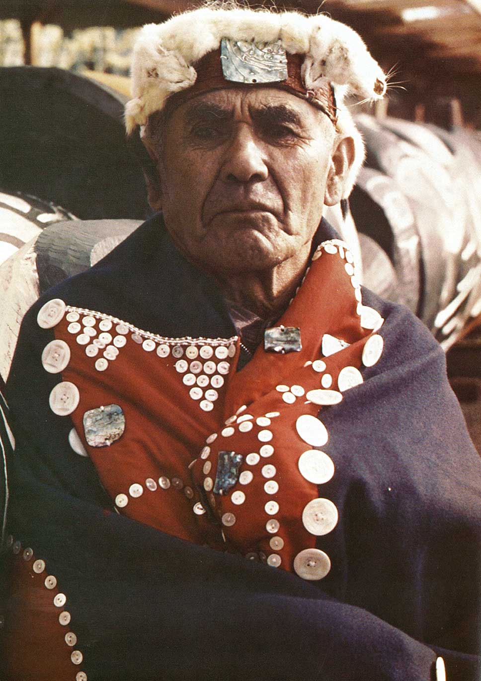 Colour photograph of Mungo Martin wearing frontlet with ermine trim and abalone, shoulders and chest in button blanket
