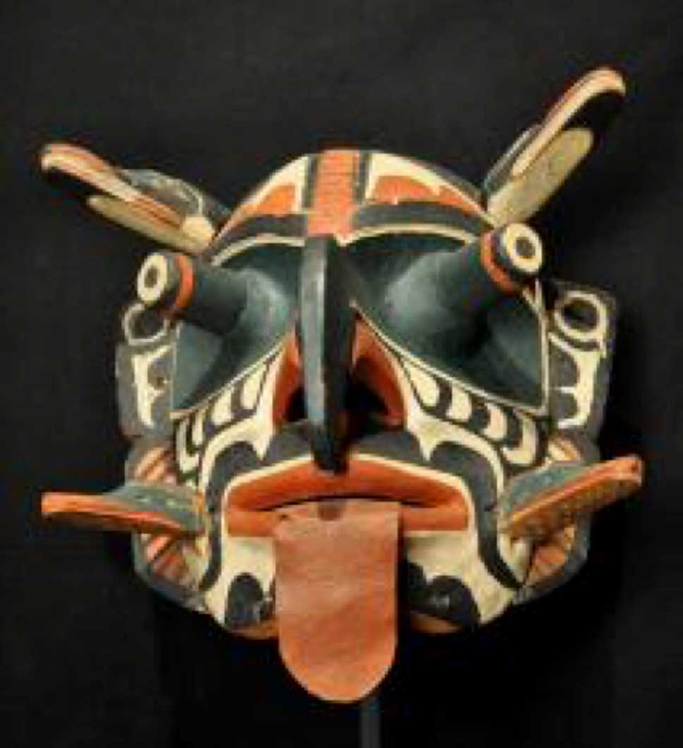 Photographie couleur un masque Xwixwi, en vue de face, prise sur un fond noir
