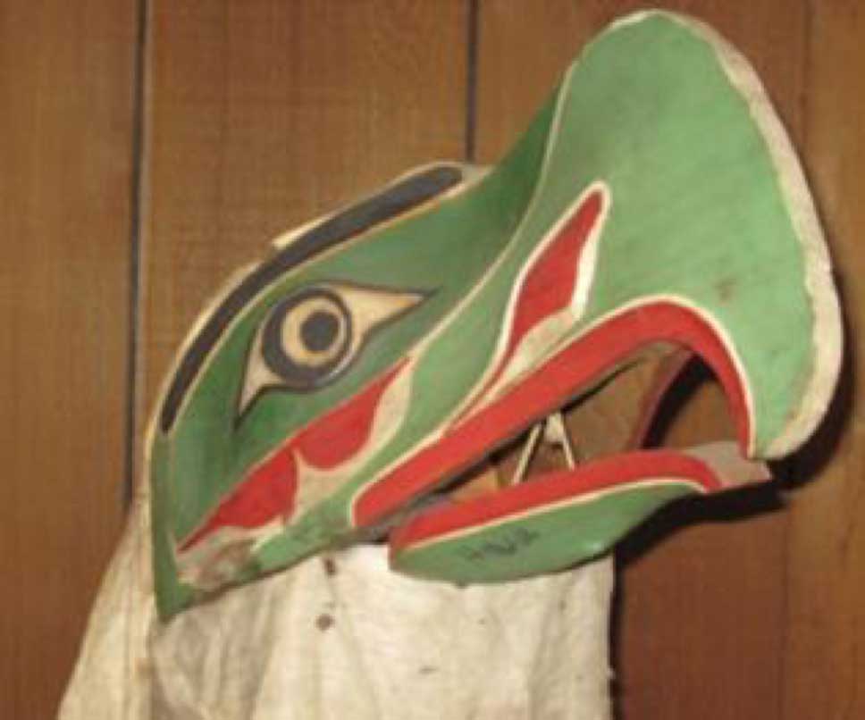Photographie d'installation du masque de Kulus, l'oiseau duveteux, prise sur un fond de cèdre