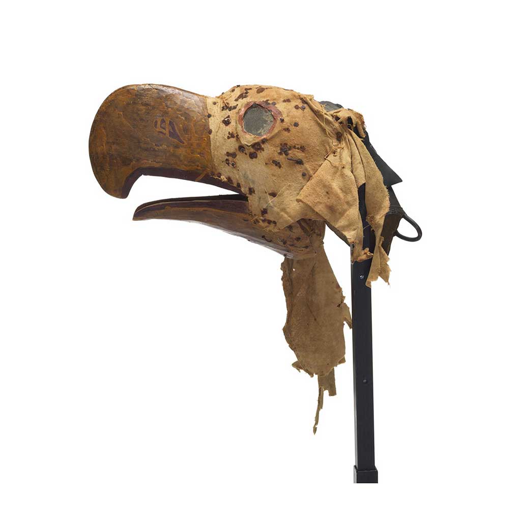 Kulus or down-covered bird, carved from cedar, broad curved beak, hinged lower jaw, mottled cloth head cover with nail fragments and rust blotches.