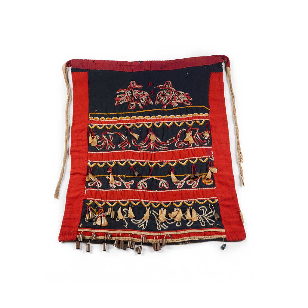 Un tablier de danse Tsep, à bords rouges sur fond noir, brodé de corbeaux et de motifs floraux, orné de becs de macareux, de dés à coudre et de douilles.