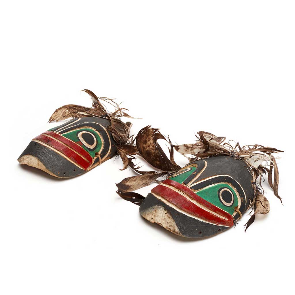 Kneecaps with frog faces, feathers attached, part of Bak´was costume, black and green with red mouth.