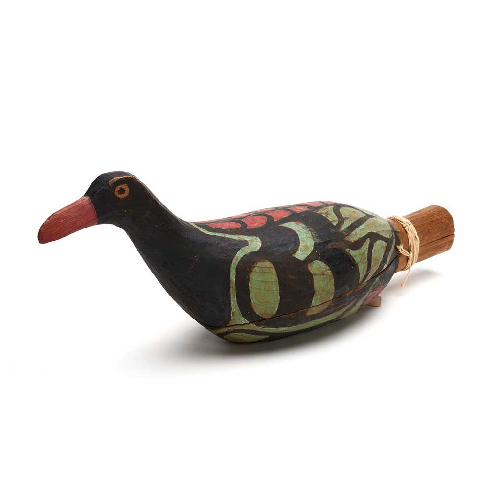 A Yadan or rattle in the shape of a bird, one of a group, carved in cedar, black with green and red markings.