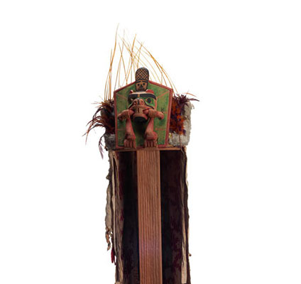 D'une coiffe Yaxwiwe' au castor, un bâton en bouche, la queue relevée, fixé sur une couronne ornée de moustaches d'otaries et d'une traînée de coton et d'hermine.