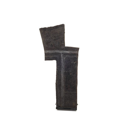 Tłakwamut, fragment de Cuivre de forme irrégulière, peint en noir, visage gravé et bords rugueux.