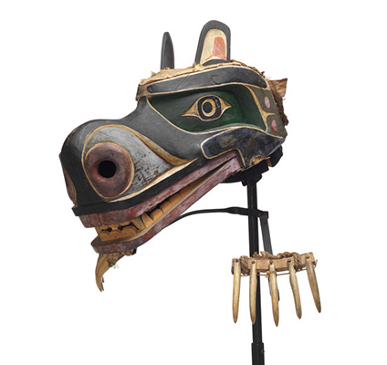 Nan or grizzly bear mask with claws made of whale bone, attached to stand by wire supports, mask is painted black and green with red and white detailing