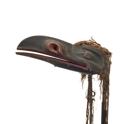 A raven headdress, dark appearance, hinged beak with green paint around eyes, red trim around beak and nostrils with thin and worn cedar trim.