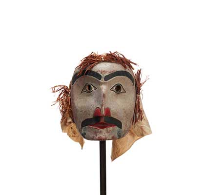 Un masque d'esprit sylvestre Atłakima en cèdre, visage rond peint en blanc, cheveux d'écorce de cèdre, voile de coton, moustache et sourcils proéminents noirs.