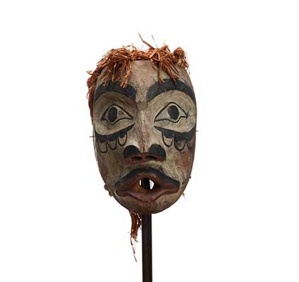 Un masque d'esprit sylvestre Atłakima d'apprêteur du sol (Wawaxanuwilana), blanc avec des marques noires sur les joues, des lèvres pincées rouges et une moustache.