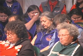 A group of Kwakwaka’wakw taking part in a mourning ceremony during a Potlatch, front row of elders in button blankets.