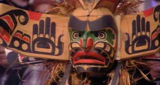 Close-up view of a transformation mask, carved from cedar and brightly decorated, shown in the open position.