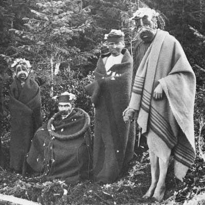Photographie noir et blanc de membres de la confrérie secrète des Nułamał, prise à Fort Rupert, vers 1894.