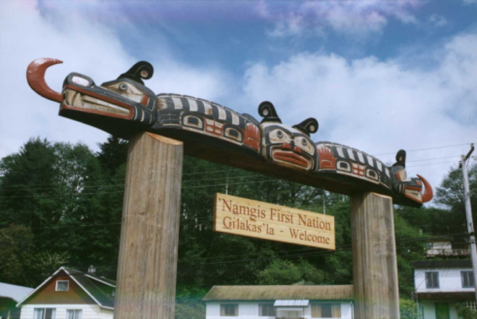Large Sisiyutł Welcome Sign spanning two carved cedar posts inscribed 'Namgis First Nation Gilakas'la Welcome