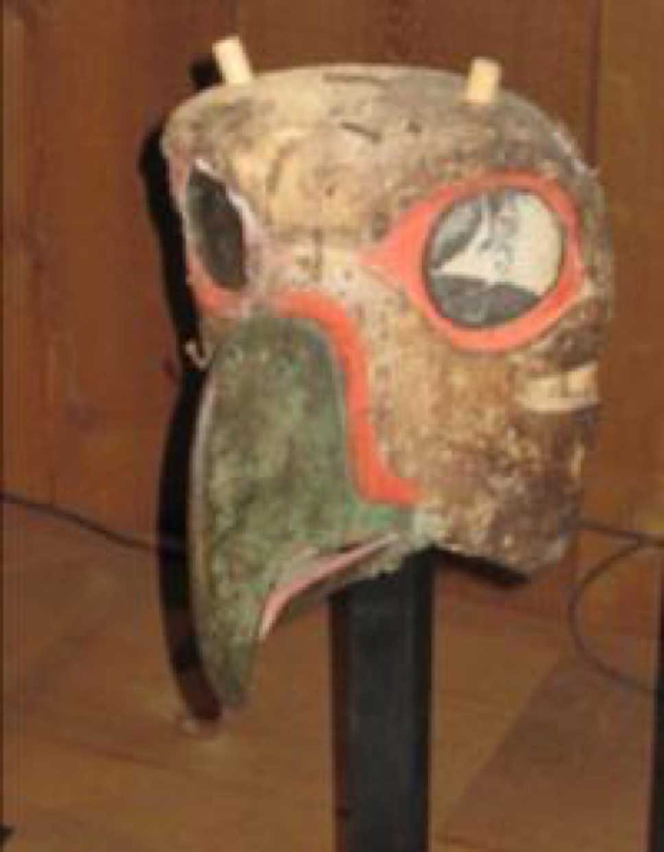 Photographie d'installation du masque de Kulus, l'oiseau duveteux, prise sur un fond de cèdre