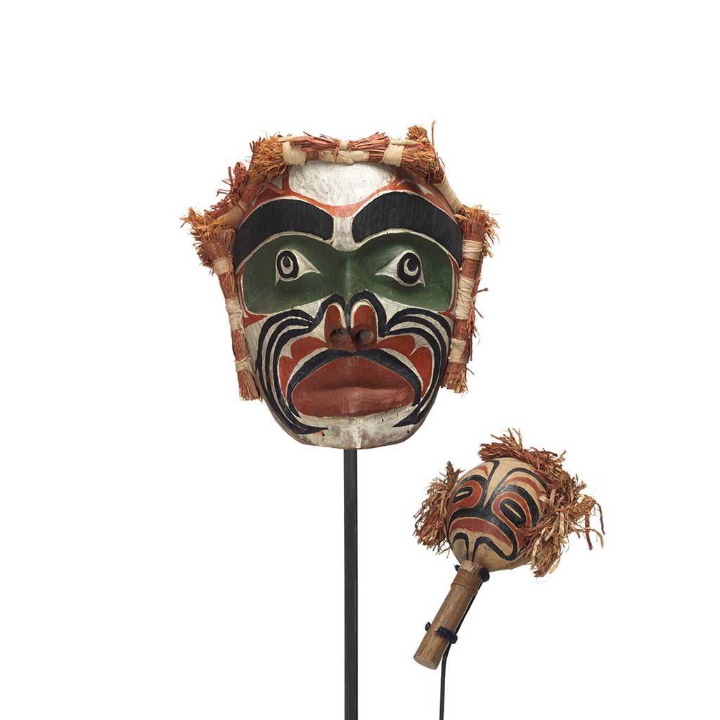 Un masque d'ancêtre Imas et un Yadan, hochet, à motif noir, vert, rouge et blanc avec des bottes d'écorce de cèdre sur trois côtés.