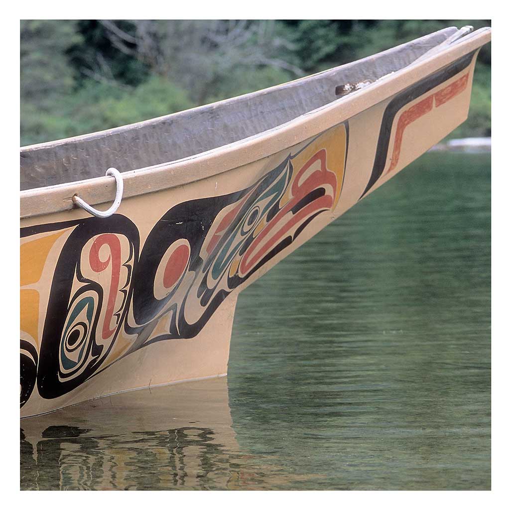 Photo couleur montrant la proue un canoë, un personnage de couleurs vives est peint sur la coque.