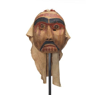 Mourning mask red paint drips on forehead, cheeks and chin. Black moustache and eyebrows. Eye holes on upper cheek.