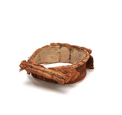 D'une coiffure d'écorce de cèdre Tłagakwame', avec des rangées d'écorce cousue sur un anneau de coton, surmonté de cordes et de touffes d'écorce.