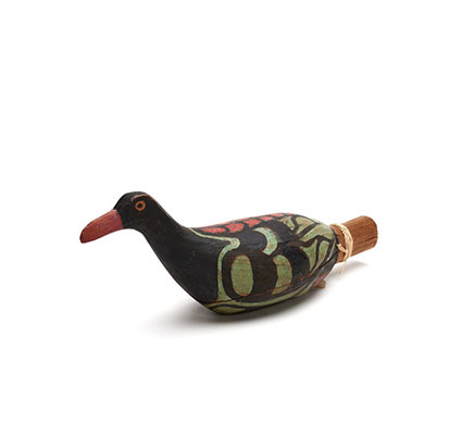 A Yadan or rattle in the shape of a bird, one of a group, carved in cedar, black with green and red markings.