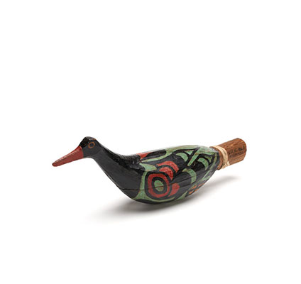 Un hochet Yadan en forme d'oiseau, partie un lot, en cèdre sculpté, peint en noir avec du vert et du rouge.