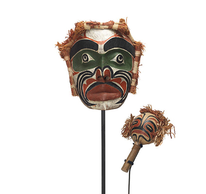 Un masque d'ancêtre Imas et un Yadan, hochet, à motif noir, vert, rouge et blanc avec des bottes d'écorce de cèdre sur trois côtés.