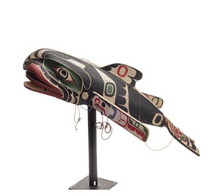 A large whale mask, black green and white painted markings with articulating mouth, fins and tail.
