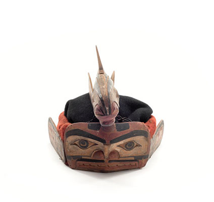 A salmon headdress, topped by a carved whale, two side and two tale fins attached, cedar with black and red details.